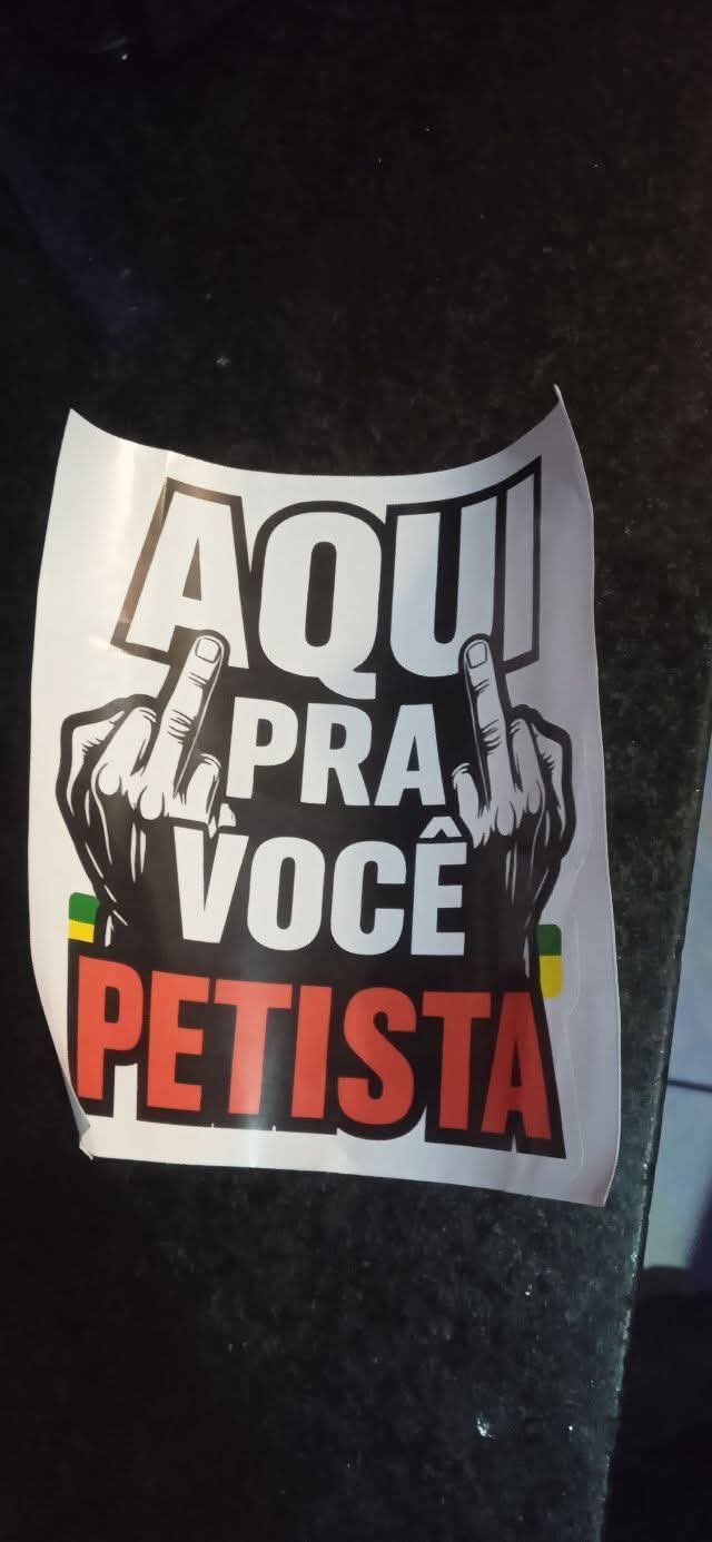 Adesivo com duas mãos fazendo gesto obsceno e a frase Aqui pra você petista.