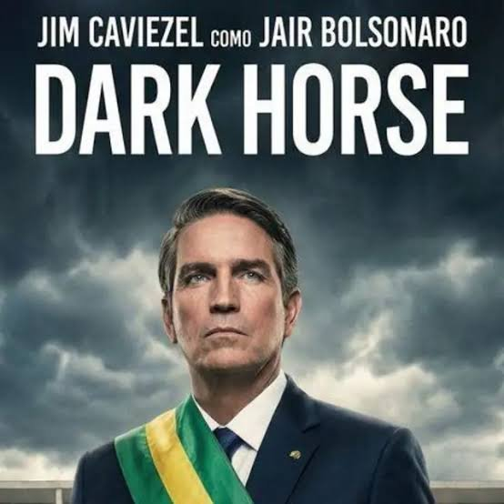 Pôster do filme Dark Horse com Jim Caviezel no papel de Jair Bolsonaro, de faixa presidencial, sob céu carregado.